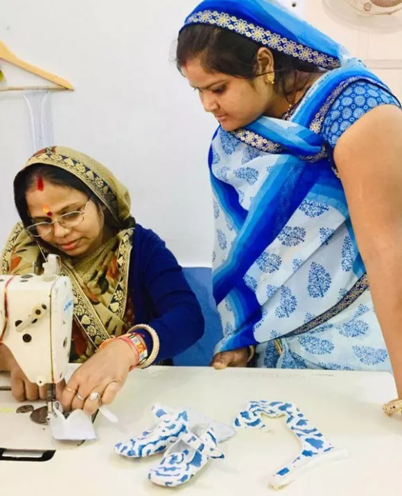 Two women of the Foundation stitiching the baby chatelles