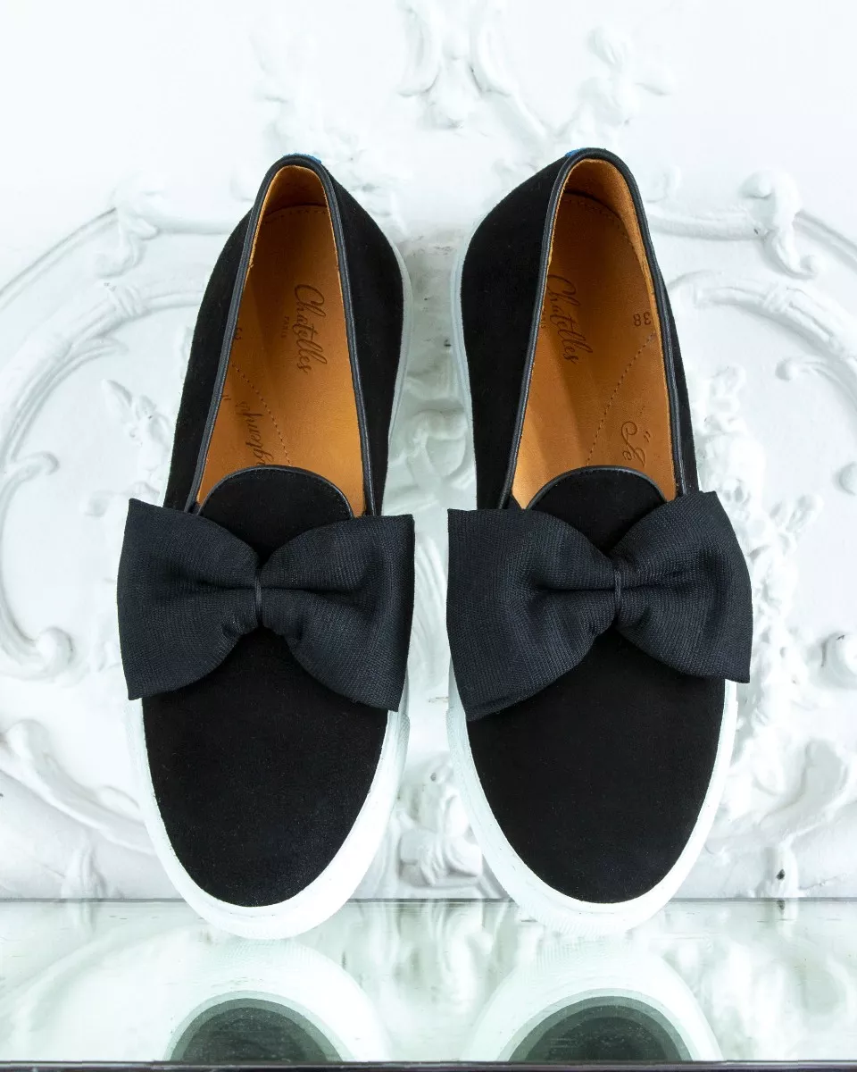 Black suede slip-ons with oversize bow