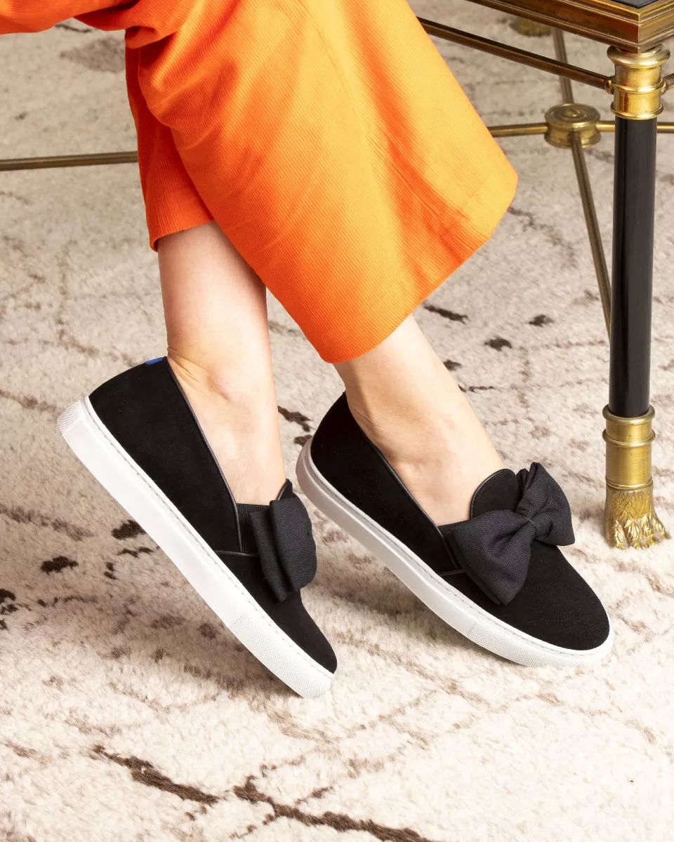 Black suede slip-ons with oversize bow