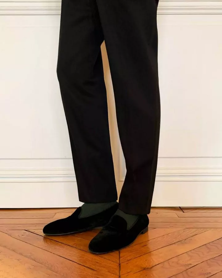Men black velvet slippers worn by a man indoors