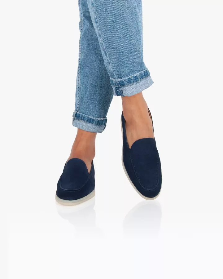 Mocassins en daim bleu portés jambes croisées