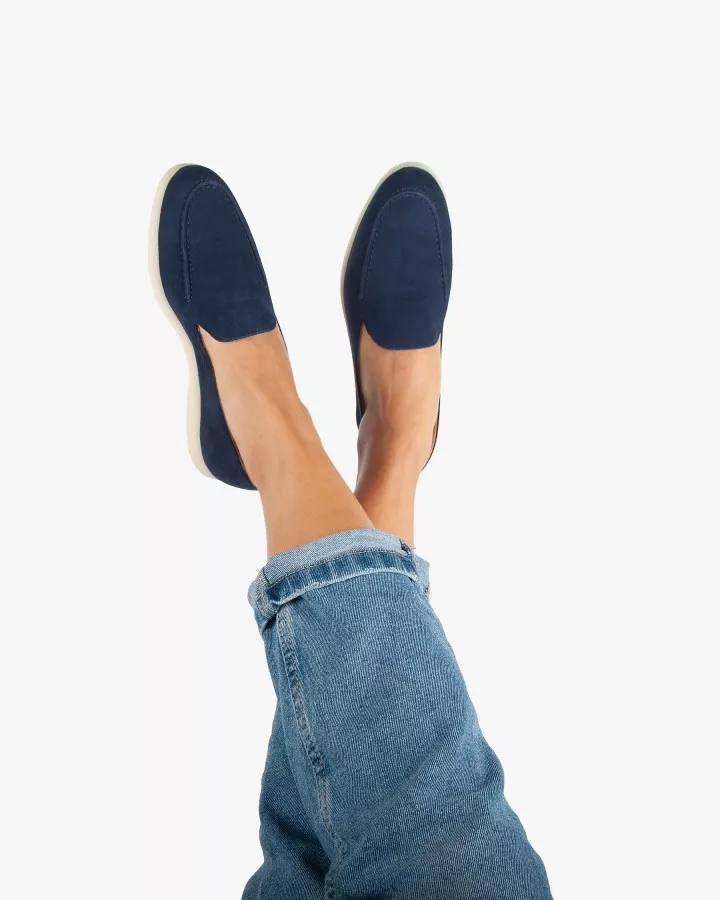 Mocassins en daim bleu portés jambes croisées levées