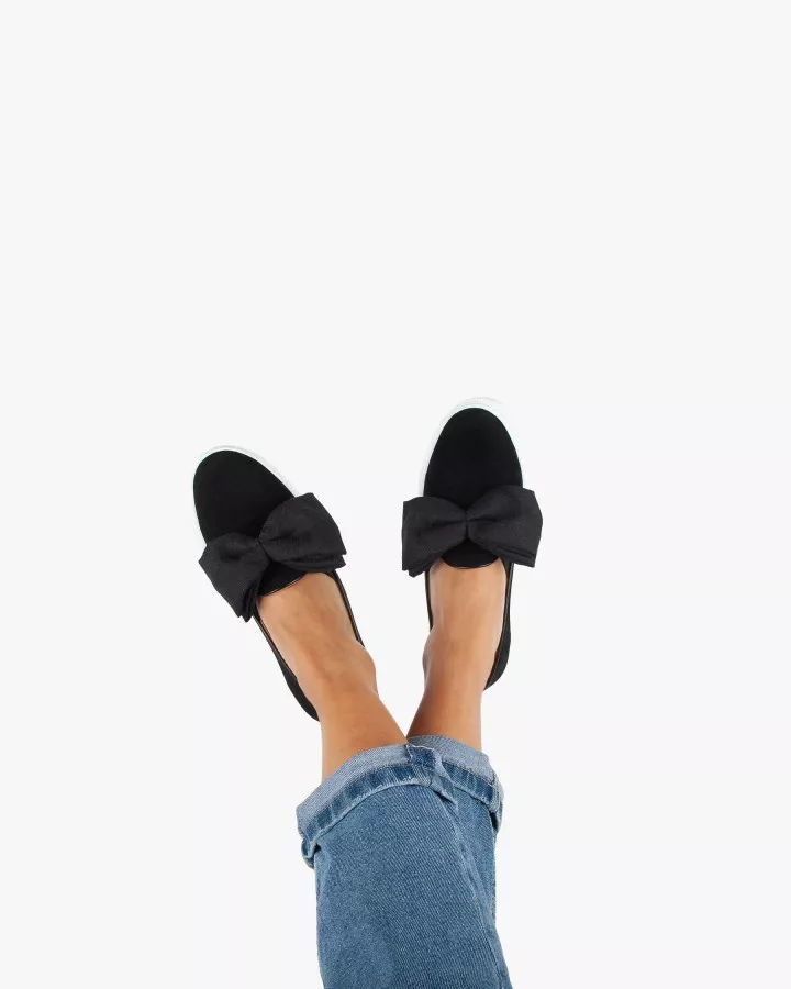 Black suede slip-ons with oversize bow