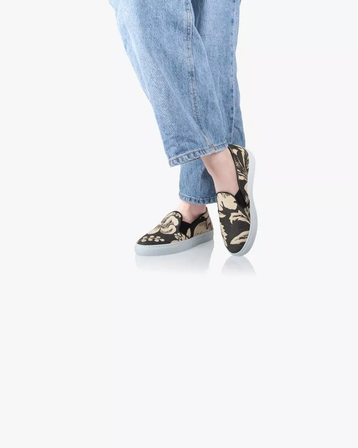 Canvas slip-ons with a pattern of large Black and Cream poppies