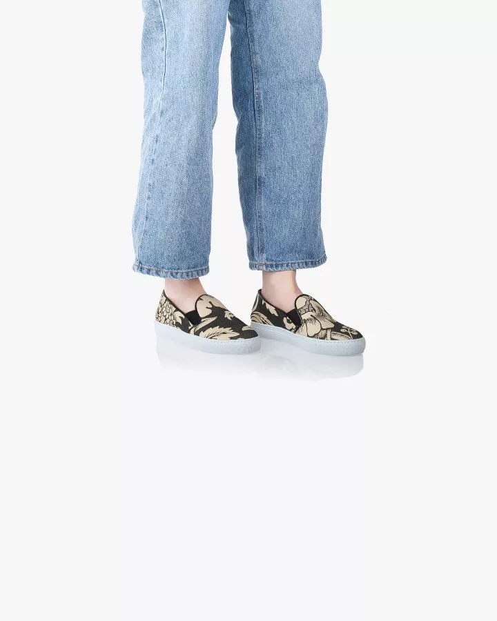 Canvas slip-ons with a pattern of large Black and Cream poppies