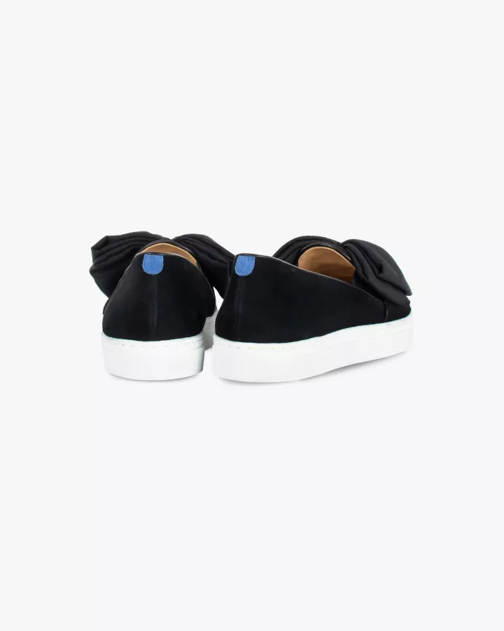 Black suede slip-ons with oversize bow